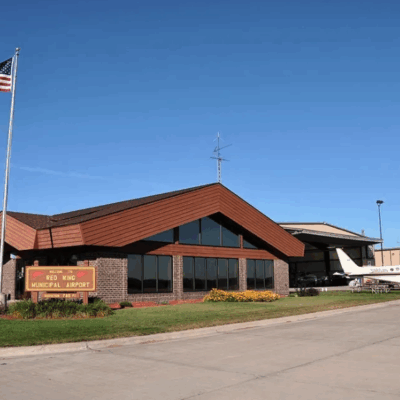 Photo of Red Wing Airport building with plane and American flag. Located in Hager City, WI
