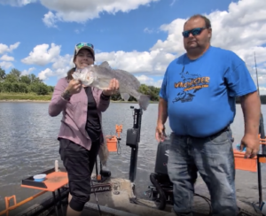 Photo of Chris of Winchester Adventures 
leading an excursion and a gal holding up the fish she caught
